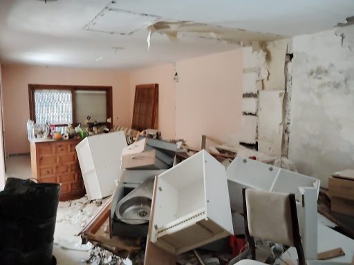 Creando espacios nuevos Habitación desordenada con muebles y electrodomésticos volcados y paredes deterioradas.